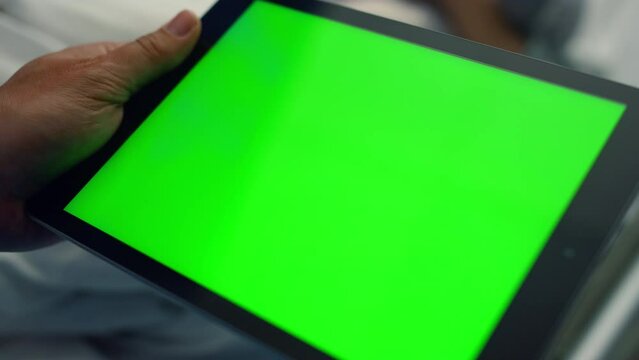 Man holding tablet computer with chroma key screen in clinic room close up.