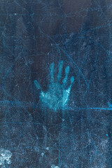 Dark blue old abandoned concrete wall with a handprint