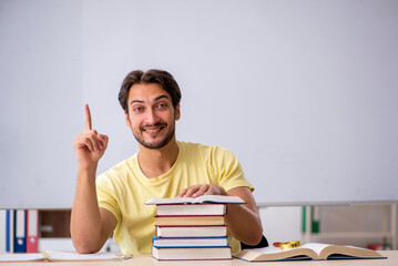 Young male student preparing for exams in the classroom