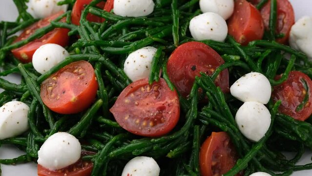 Fresh Samphire salad with cherry tomatoes and mozzarella. Healthy food. Rotating video