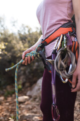 Fototapeta na wymiar A rock climber prepares equipment for climbing, woman holds a rope, knot