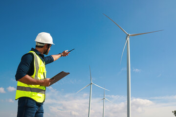 Portrait smart engineer point hand to the wind turbine communicating with team , outdoor working in smart farm, Green energy and Earth day concept