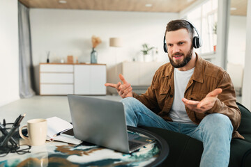 Man Wearing Headset Making Video Call On Laptop At Home