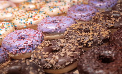 Close up of different donuts with sugar, frosted, glaze, and sprinkles.