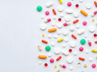 Creative layout of colorful pills and capsules on green background. Minimal medical concept....