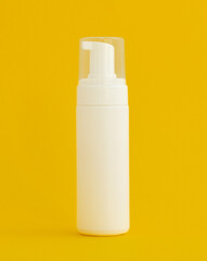 Cosmetics, Moisturizer, Bottle. Blank plastic cosmetics bottle on yellow background with copy space