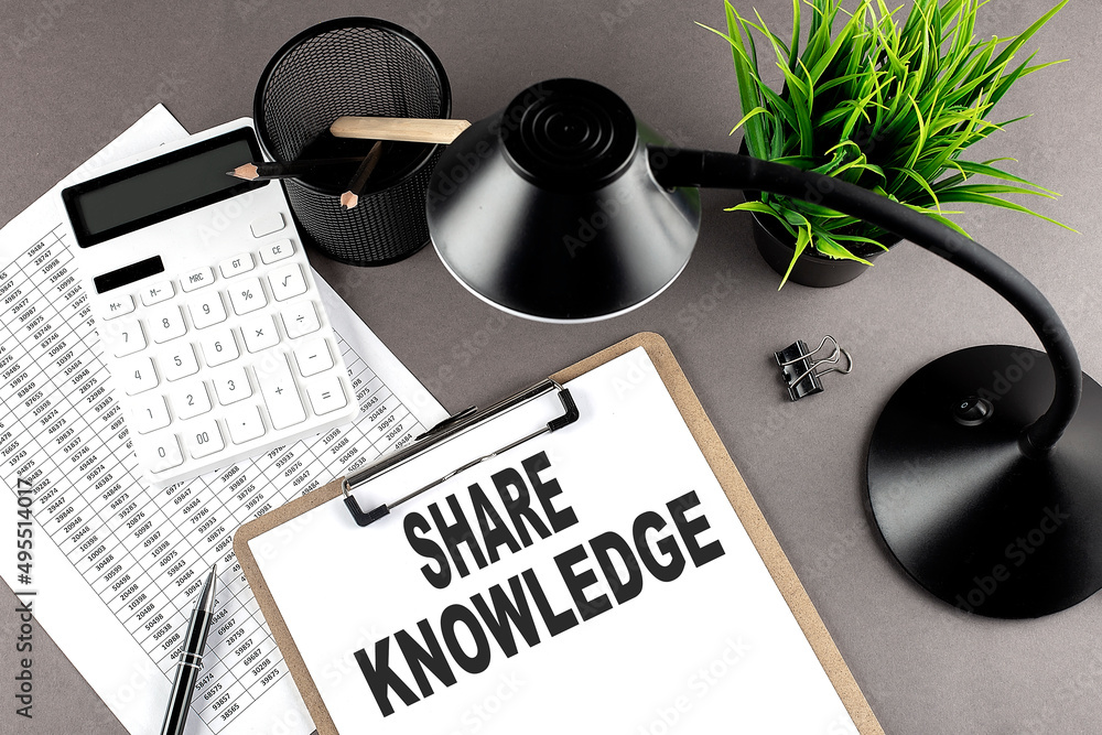 Poster clipboard ,chart and calculator, lamp and workspace accessories on a grey table. top view , text sha