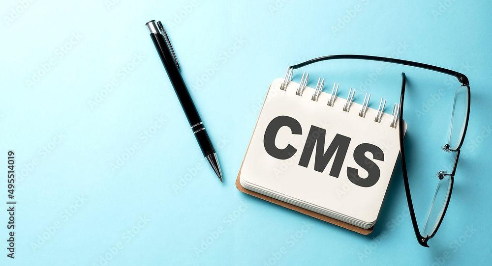 Aufkleber cms text written on a notepad on the blue background