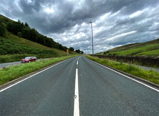 Heavy rain clouds above the, Burnley Road, with a car in the layby, next to  moorland near, Todmorden, Yorkshire, UK