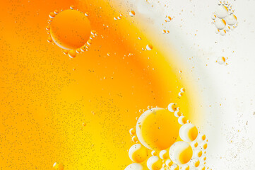 Abstract background with water and oil. Blurred shapes and textures in yellow, orange and white...