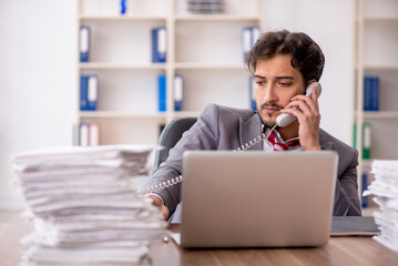 Young male employee unhappy with excessive work in the office