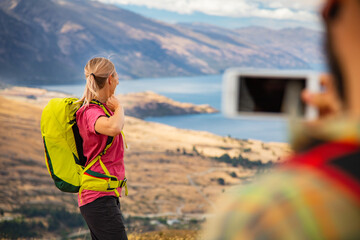 Successful couple taking picture Lake Wakatipu South Island