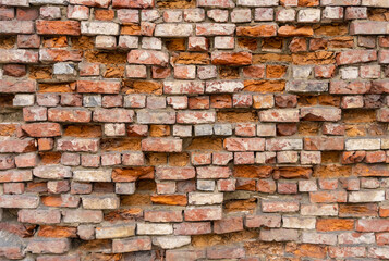 Old and damaged brick wall background with dropped out  bricks.