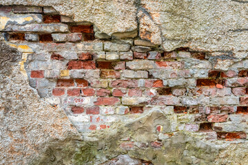 Old brick wall with crack, cement and plaster peel off. Background, texture. Closeup.