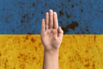 Support for Ukraine and solidarity. Children's hands on the background of the Ukrainian flag. The...
