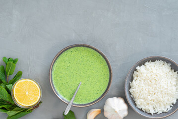 Healthy fresh green chutney sauce. With fresh mint pudina and yogurt. Spicy indian cuisine. Served with rice, lemon, garlic and parsley. Top view, grey background, copy space