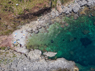 Drone aerial above beautiful coastline, turquoise clear sea water, wild nature, Zingaro Nature Reserve, Sicily. Tropical travel holiday near Scopello.