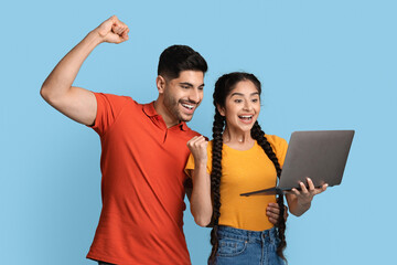 Online Profit. Euphoric Young Arab Couple Celebrating Success With Laptop