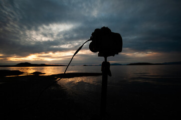 silhouette of a camera on the beach at sunset
