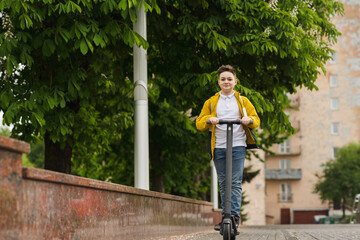 Joyful teenager rides on electric scooter outdoor