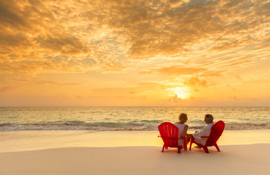 Senior couple enjoying beach vacation at sunset Bahamas
