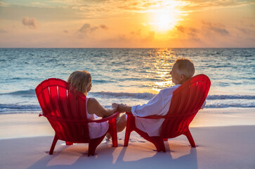 Retired couple relaxing by the ocean at sunrise
