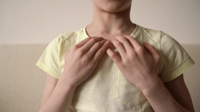 Child practicing EFT or emotional freedom technique - tapping on the collarbone point, slow motion