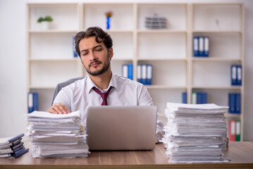 Young male employee and too much work in the office