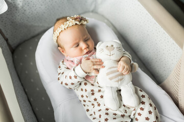 a small beautiful baby lies in his cradle in a soft cocoon