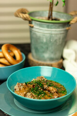 Buckwheat with meat and sauce in a blue plate, sprinkled with herbs. On a dark table. The concept of lunch, or a hearty dinner