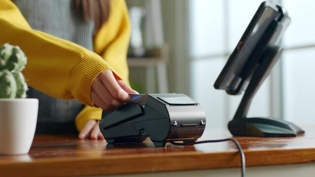 Customer using credit card for payment to owner at cafe restaurant, cashless technology and credit card payment concept