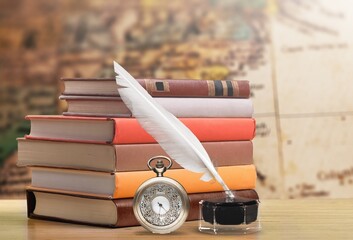 Antique table with books and inkwell with pocket watch. Vintage background. Concept history.