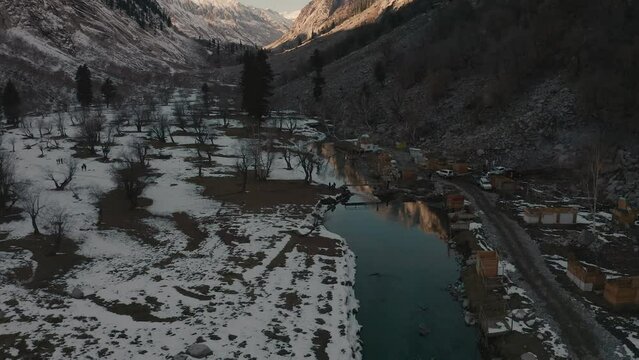 Aerial view of a river in between the mountains covered with snow at Swat valley, Pakistan