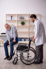 Obraz premium Old man in wheelchair visiting young male doctor