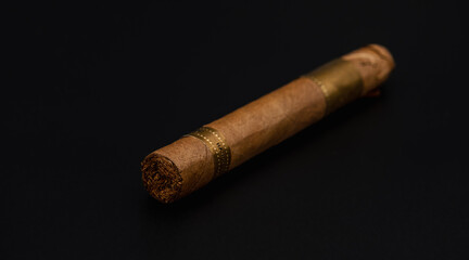 Single cigar. Handcrafted Brown cigar made with real tobacco leaves on dark background