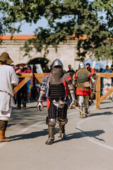 A strong knight, a warrior stands walking across the battlefield, guarding the state in armor with...