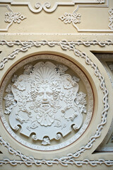 Plaster mask of Dionysus in the ceiling caisson.  A fragment of a coffered ceiling in a historic building with a stucco decoration in the form of a Dionysus mask.  