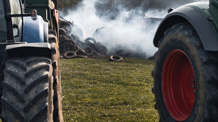 Agricultural tractors and burning tires, demonstration on the cost of fuel. Close up