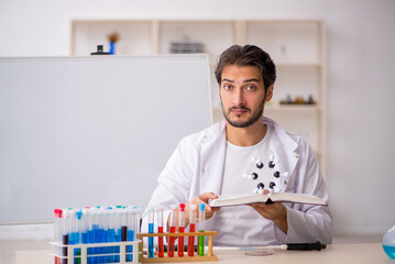Young male chemist working at the lab