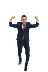 young businessman celebrating the victory with his arms up