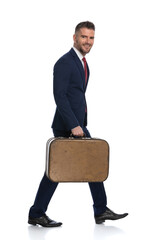 happy businessman taking his luggage and moving towards his holiday