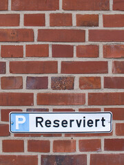 Fototapeta na wymiar Schild Reservierter Parkplatz mit Hintergrund 