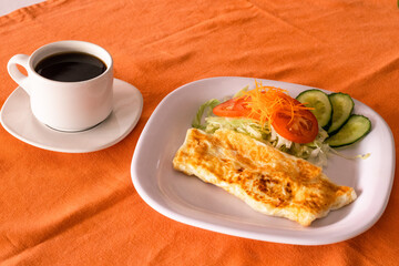 Omelette con taza de café y ensalada 