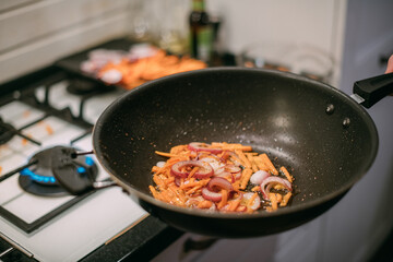 Frying pan with vegetables and meat close-up.