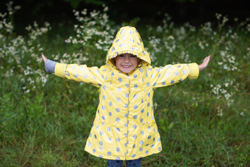 Portrait of a funny girl in a yellow raincoat. Springtime