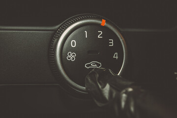 A man in rubber gloves turns on the air conditioner in the car. The driver turns on the car's climate control system. travel by car. Close-up view with selective focus.