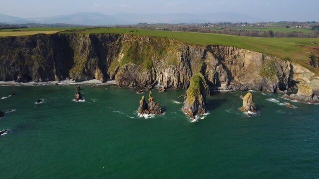 huge rocks and cliffs in the middle of the Atlantic Ocean in a UNESCO protected geopark, Stradbally Cove, on the Cooper Coast, Waterford, Ireland.