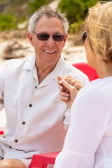 Smiling senior couple holding hands on beach Bahamas