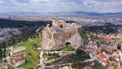 Selbstklebende Fototapeten Aerial drone photo of unique Masterpiece of Ancient times the Parthenon on top of iconic Acropolis hill with cloudy sky, Athens, Attica, Greece © aerial-drone