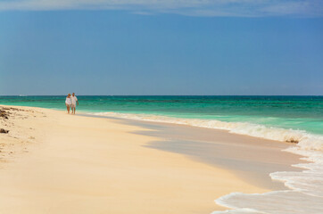 Fototapeta na wymiar Retired Caucasian couple walking on deserted beach Bahamas